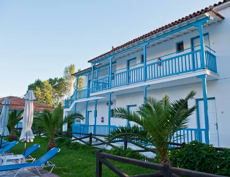 A building with blue balconies behind the palm trees