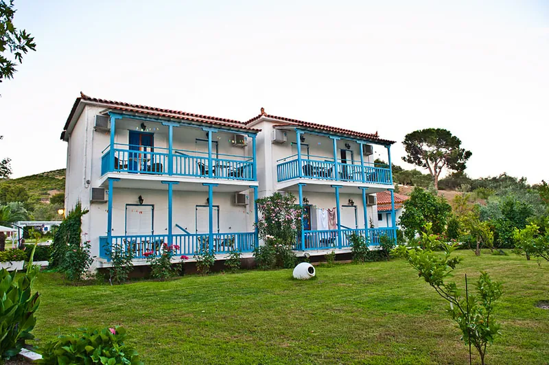 A two-storey building with blue balconies over the lawn