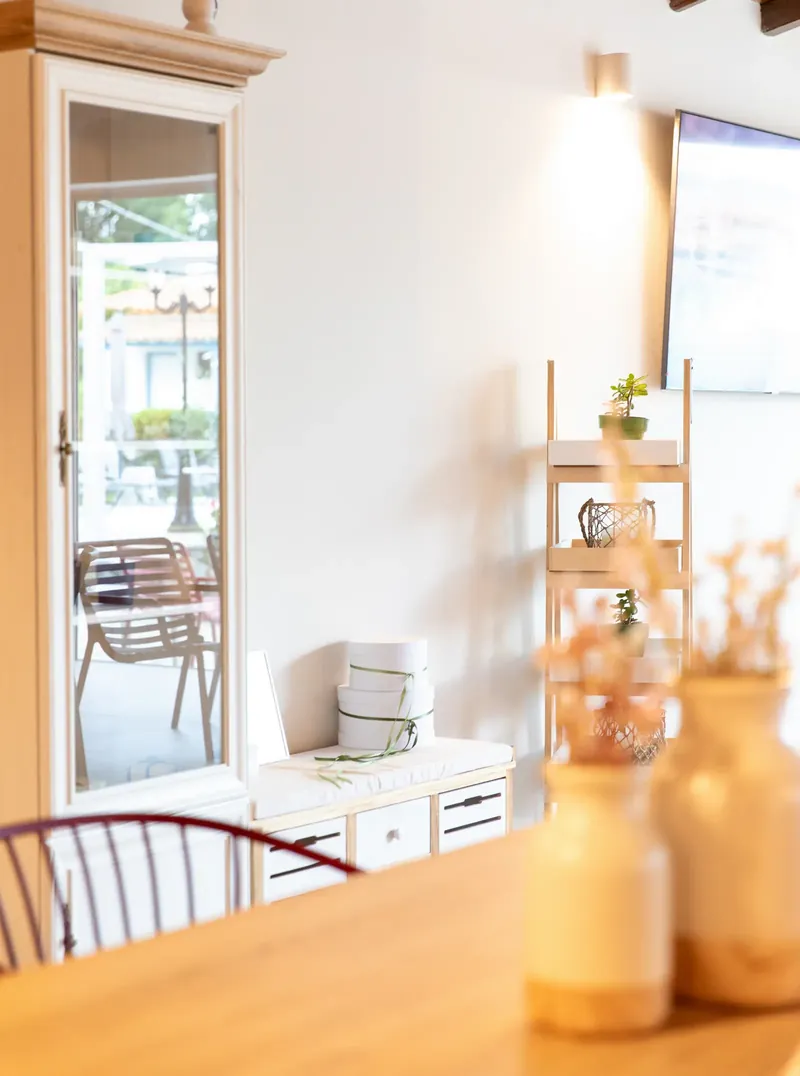 A vase and bottles on a white shelf in the lobby