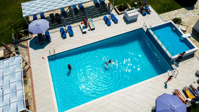The pool and the children's pool from above, with sunbeds and umbrellas