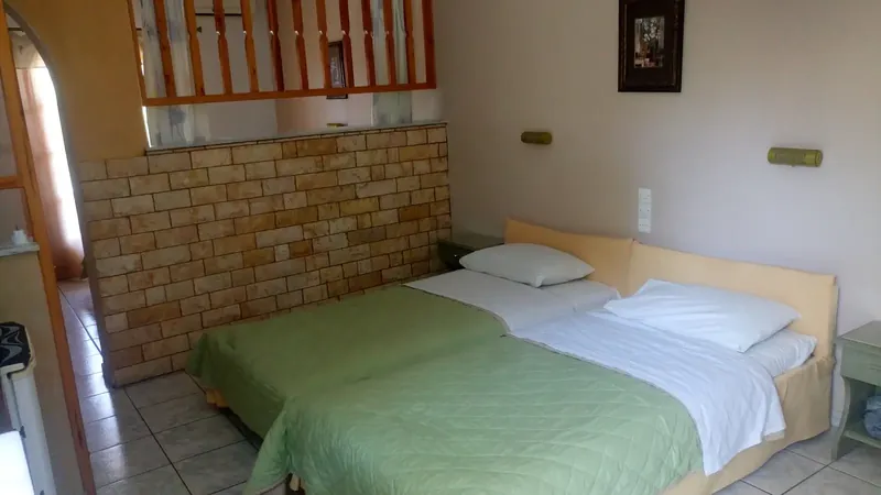 A twin room with a stone wall and a loft above