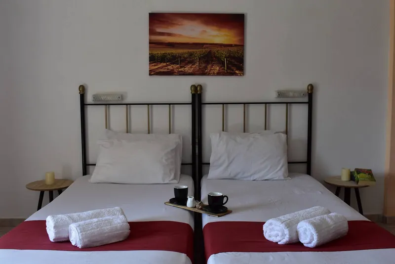 Twin beds under a sunset painting