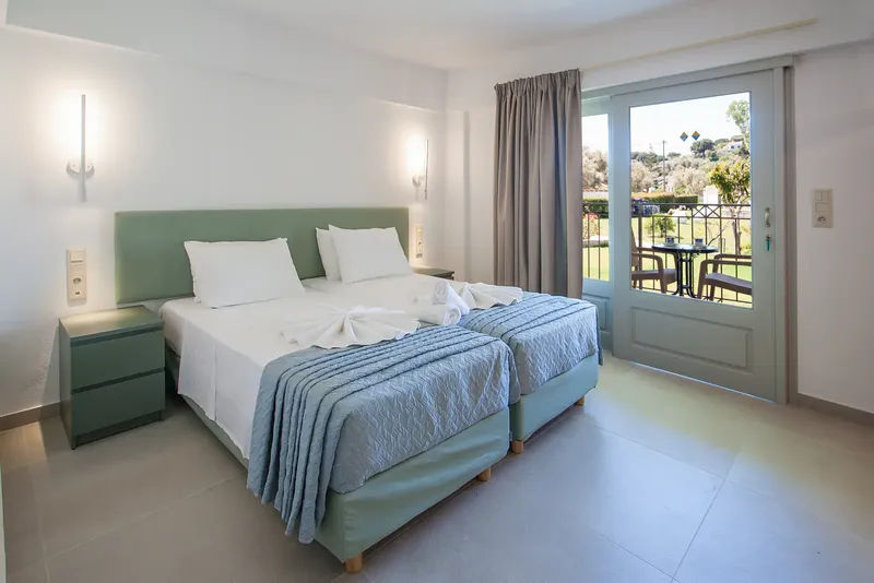 A twin room with balcony doors looking out to the garden