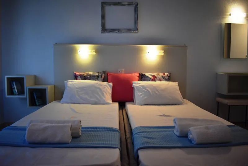 A twin room with blue covers and reading lights